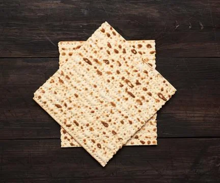 Stack of baked square matzo on a brown wooden background Stock-Fotos