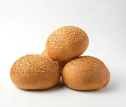 Stack of baked whole round bun with sesame seeds made from white wheat flour Stock Photos
