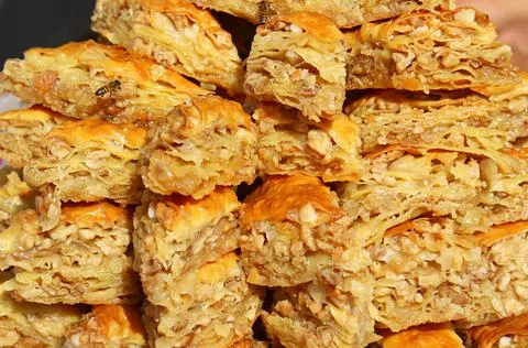 Stack of Baklava Pastries Attracting Tiny Bees at the Local Market of Armenia Photos