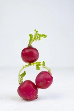 A stack of balancing fresh radish on white background. Stock Photos