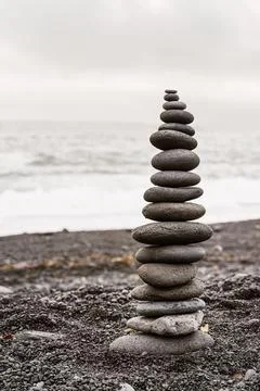 Stack of balancing rock on seashore on overcast day Foto stock