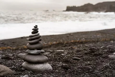 Stack of balancing rock on seashore on overcast day Foto stock