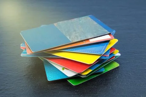 Stack of bank cards on a black background. Stock Photos