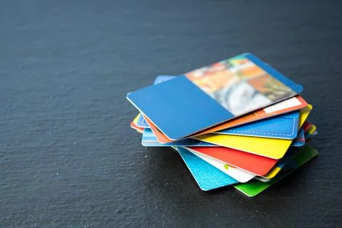 Stack of bank cards on a black background. Stock Photos