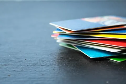 Stack of bank cards on a black background. Stock Photos