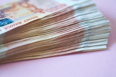 A stack of banknotes 5000 rubles on a pink background. Stock Photos