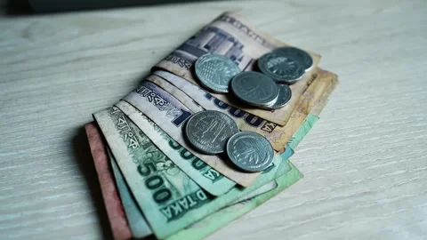 Stack of Banknotes and Coins on Wooden Surface, A stack of various denomina.. Stock Footage 304911120