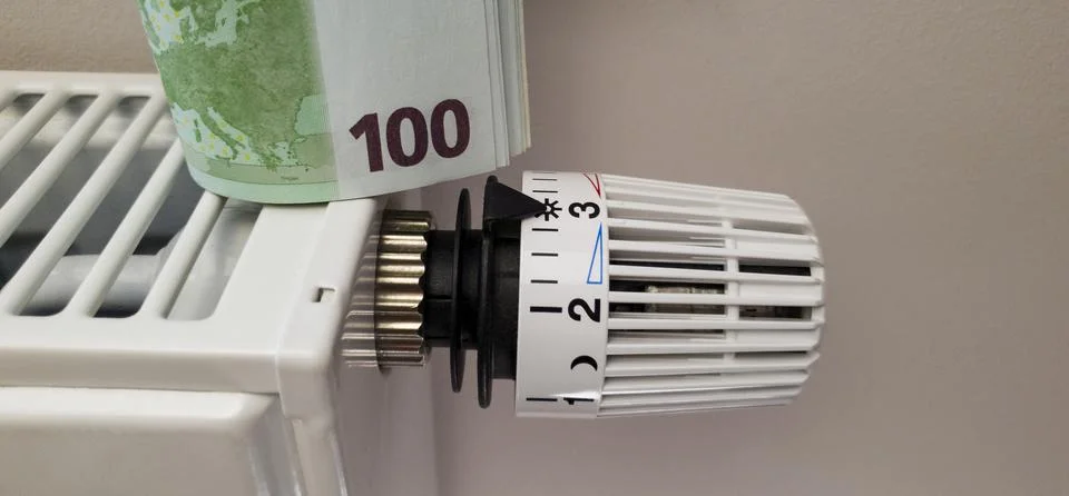 A stack of banknotes on the batteries of a central heating radiator Stock Photos