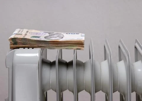 Stack of banknotes on an electric heating radiator Foto stock