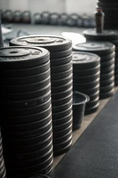 Stack of barbell plates stacked on movable pegs on wheels in gym Stock Photos
