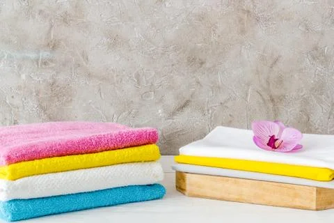Stack of bath towels and clothes on ironing board Stock Photos