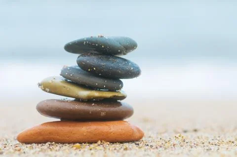 Stack of beach stones on sand. ocean in the background 스톡 사진