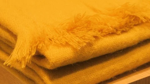 Stack of the beautiful colored woolen blankets in a yellow, brown, green color 스톡 동영상 122929917