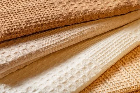 Stack of beige and cream colored waffle kitchen towels folded into folds clos Stock Photos