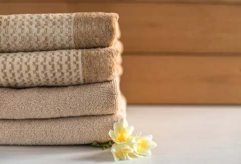 Stack of beige towels on wooden background. Foto stock