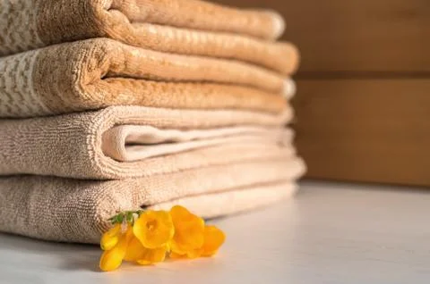 Stack of beige towels on wooden background. Foto stock