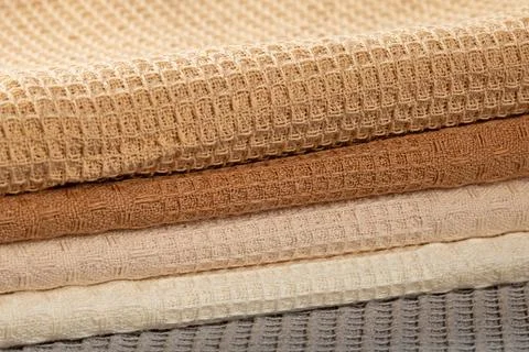 Stack of beige,gray and cream colored waffle kitchen towels folded into folds Stock Photos