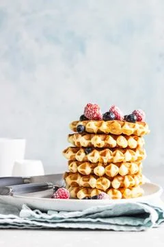 Stack of belgian vanilla waffles with berry and honey. Stock Photos