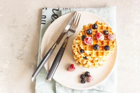 Stack of belgian vanilla waffles with berry and honey. Stock Photos