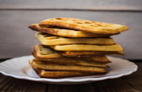 Stack of belgian waffles on a white plate wooden background Stock Photos