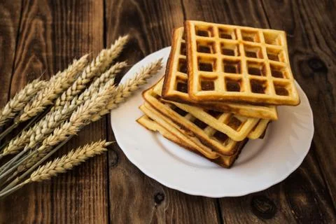 Stack of belgian waffles on a white plate wooden background Stock Photos