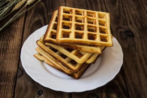 Stack of belgian waffles on a white plate wooden background Stock Photos