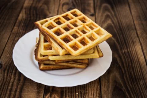 Stack of belgian waffles on a white plate wooden background Stock Photos