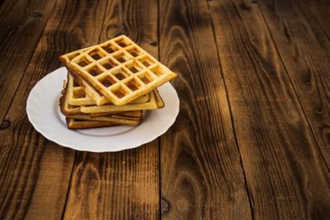 Stack of belgian waffles on a white plate wooden background Foto stock