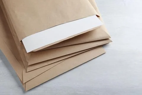 Stack of big kraft paper envelopes on light table, closeup Foto stock