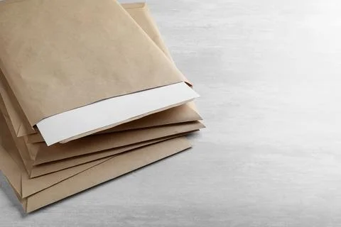 Stack of big kraft paper envelopes on light table, closeup Foto stock