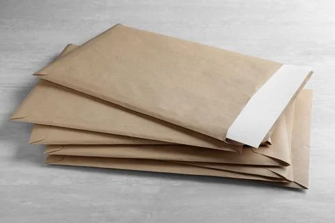 Stack of big kraft paper envelopes on light table, closeup Foto stock
