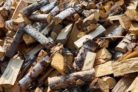 Stack of birch firewood with hand chopping block. Chopped firewood for winter Stock Photos