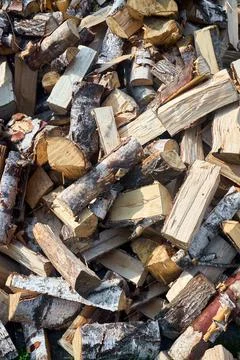 Stack of birch firewood with hand chopping block. Chopped firewood for winter Stock Photos