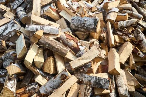 Stack of birch firewood with hand chopping block. Chopped firewood for winter Stock Photos