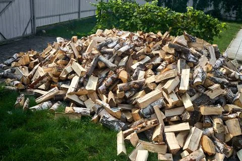 Stack of birch firewood with hand chopping block. Chopped firewood for winter Stock Photos
