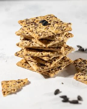 Stack of biscuit crackers with sunflowers seeds and sesame on white background Stock Photos