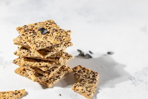 Stack of biscuit crackers with sunflowers seeds and sesame on white background Stock Photos