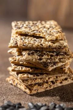 Stack of biscuit crackers with sunflowers seeds and sesame, vertical, selective Stock Photos