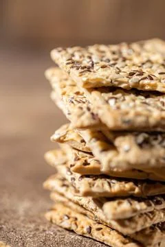Stack of biscuit crackers with sunflowers seeds and sesame, vertical selective Stock Photos
