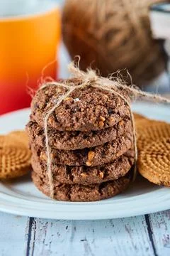 Stack of biscuits in plate and basket and a cup on blue table Stock Photos