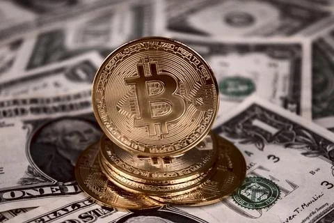 A stack of bitcoin coins on one dollar bills Stock Photos