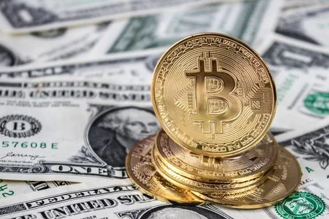 A stack of bitcoin coins on one dollar bills Stock Photos