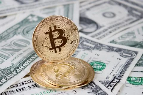 A stack of bitcoin coins on one dollar bills Stock Photos