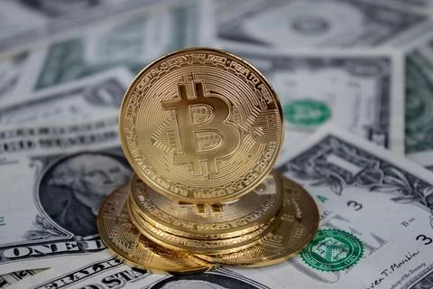 A stack of bitcoin coins on one dollar bills Stock Photos