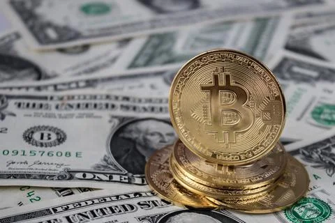 A stack of bitcoin coins on one dollar bills Stock Photos