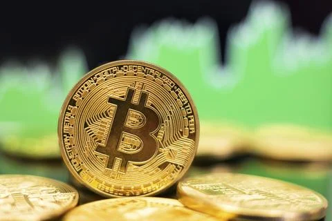 Stack of Bitcoin gold coins in front of a green bullish trend chart. Price rise Stock Photos