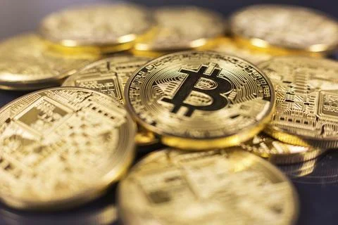 Stack of bitcoins lying on shiny dark surface Foto stock