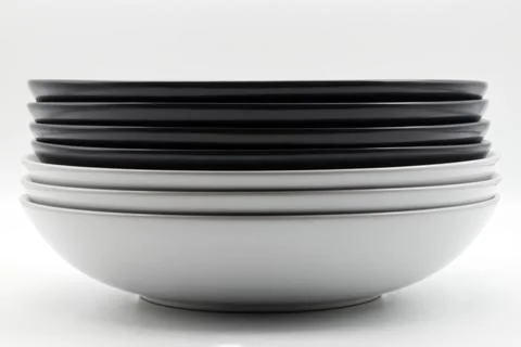 Stack of black and white dishes isolated on white background Stock Photos