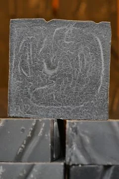 Stack of black color natural soap bar on table Stock Photos