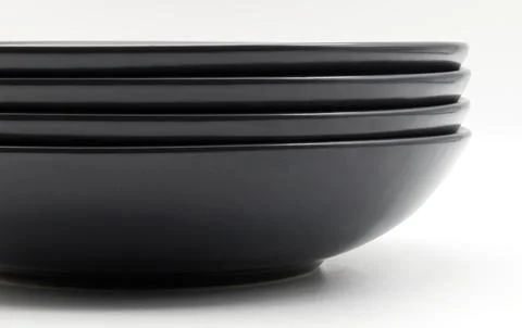 Stack of black dishes isolated on white background Stock-Fotos